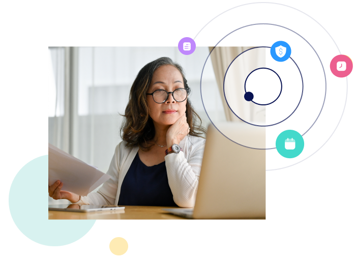 woman looking at her laptop while holding document